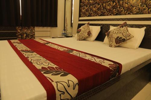 a bedroom with a large bed with red and white sheets and pillows at Hotel Royal Ajmer in Ajmer