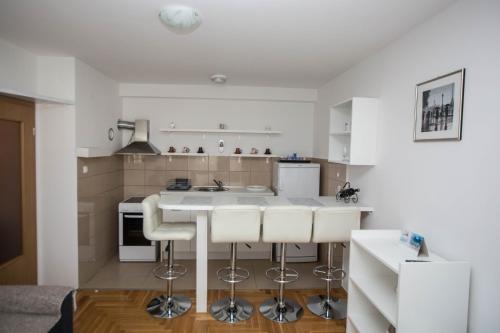een keuken met witte werkbladen en witte apparaten bij Apartman G&A in Trebinje