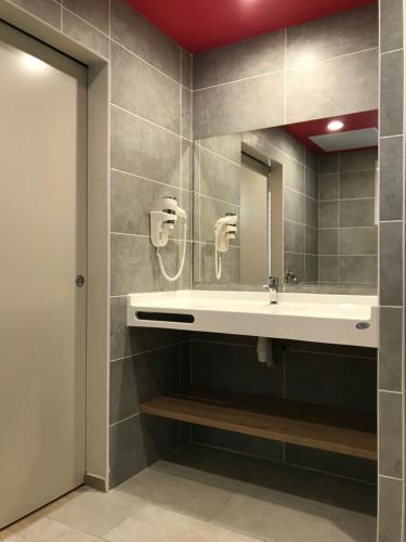 a bathroom with a sink and a mirror at Diamant les bains - Résidence Hôtelière in Le Diamant