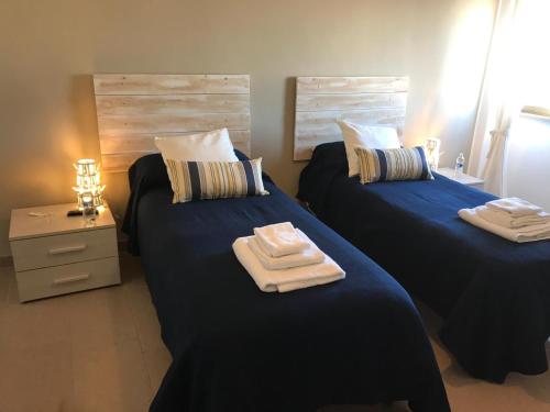 two beds with towels on them in a bedroom at la casa di mery in Tor Vergata