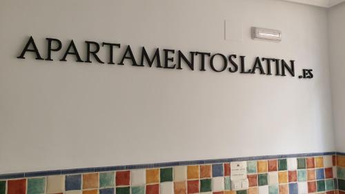 ein Schild an der Wand eines Badezimmers mit Fliesen in der Unterkunft Apartamentos Latin in Nerja