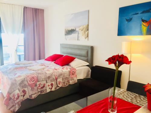 a bedroom with a bed and a vase of flowers on a table at Nova Galerija West App MARY - parking in garage in Zagreb