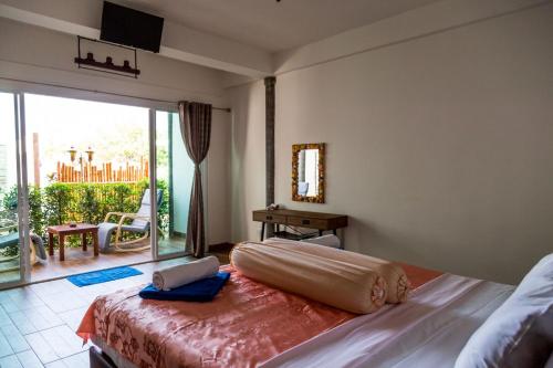 a bedroom with a large bed with a large window at Yao Yai Beach Resort in Ko Yao Yai
