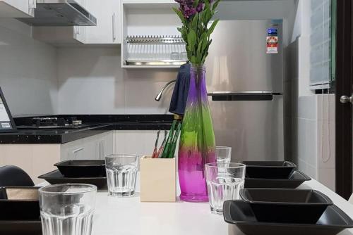 a vase with flowers on a table in a kitchen at Kyra The Heights Residence Condo Ayer Keroh Melaka WiFi, Netflix & Pool in Ayer Keroh