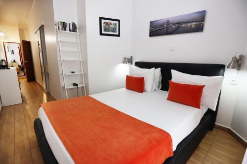 a bedroom with a bed with orange and white pillows at Anjo Azul in Lisbon