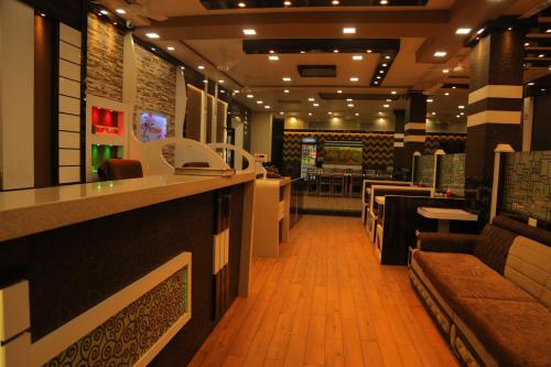 a restaurant with a bar and tables and chairs at Hotel Royal Ajmer in Ajmer