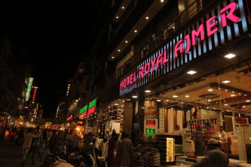 a group of people standing outside of a store at night at Hotel Royal Ajmer in Ajmer