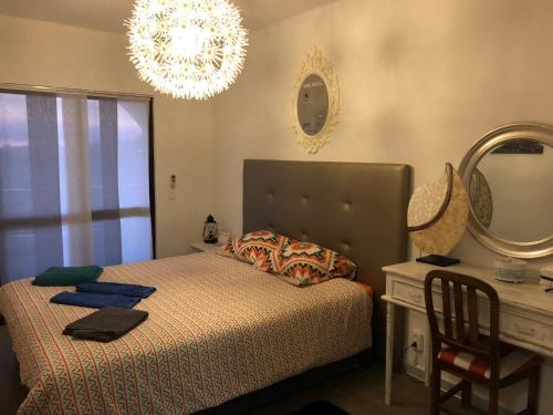 a bedroom with a bed and a desk and a chandelier at ColinaSol Vale Centeanes Appartement vue mer in Carvoeiro