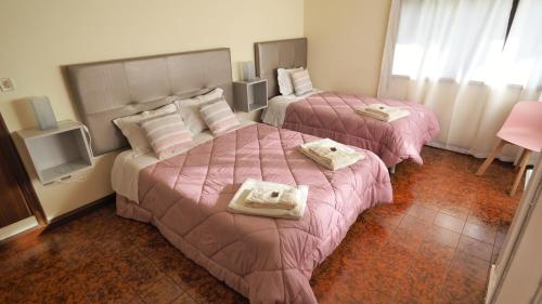 two beds in a hotel room with pink comforter at Casarão Paraíso in Perafita