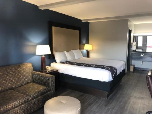 a hotel room with a bed and a couch at Scottish Inns - Locust Grove in Locust Grove