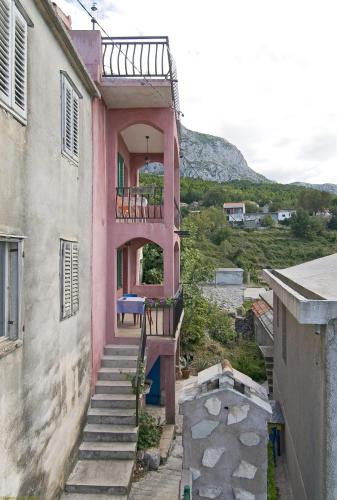 a pink house with stairs and a balcony at panoramic sea view house in Tučepi