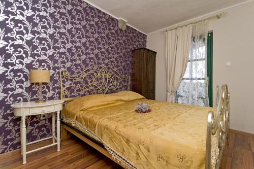 sypialnia z łóżkiem i fioletową ścianą w obiekcie panoramic sea view house w Tučepi