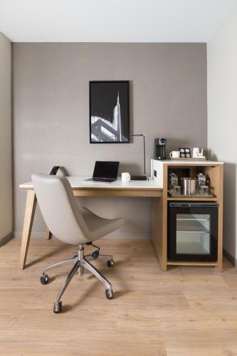 an office with a desk with a laptop and a chair at Radisson Hotel Seattle Airport in SeaTac