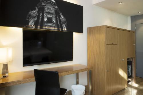 a living room with a large flat screen tv on a wall at Petit Palace Plaza del Carmen in Madrid