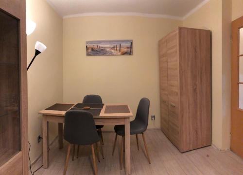 a dining room table with chairs and a desk at Apartament na Zielonej parter in Kędzierzyn-Koźle