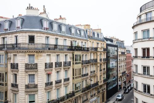 an apartment building with balconies on a city street at Hotel Yllen Eiffel in Paris