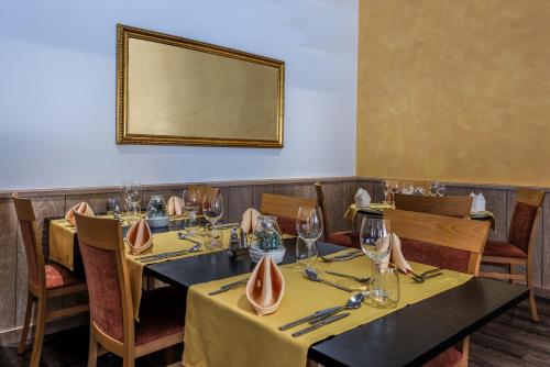 a dining room with tables and chairs and a mirror at Wellness- und Schneesporthotel Christiania in Saas-Almagell