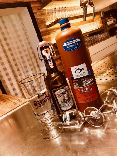 a counter with two bottles of alcohol and a glass at Waldhotel Seebachschleife in Bayerisch Eisenstein