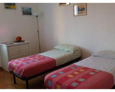 een kamer met 2 bedden en een tafel met een nachtkastje bij Tre Cipressi in Pontassieve