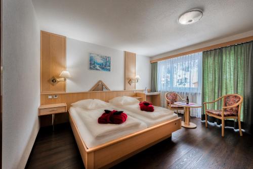 サース・アルマゲルにあるWellness- und Schneesporthotel Christianiaのベッドルーム1室(赤い枕2つ付)