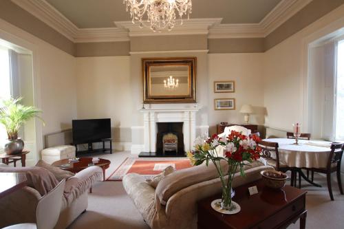 a living room with a couch and a fireplace at The Dower House Apartments in Lincoln