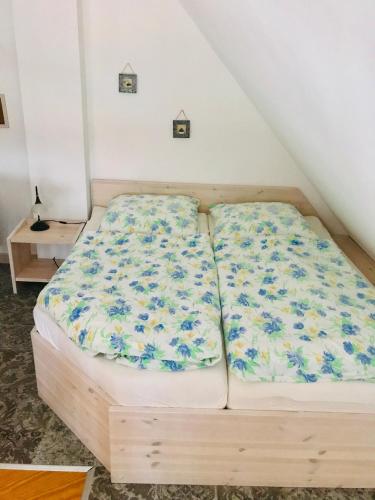 a bed with blue flowers on it in a room at "Steuermannskammer" by Ferienhaus Strandgut in Born