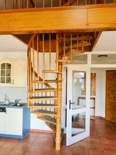 a spiral staircase in the kitchen of a house at "Steuermannskammer" by Ferienhaus Strandgut in Born