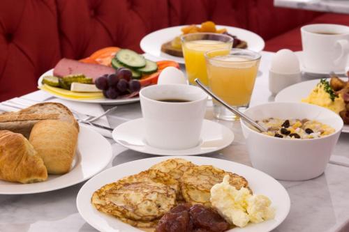 a table with plates of breakfast foods and drinks at Hotel Gamla Stan, BW Signature Collection in Stockholm