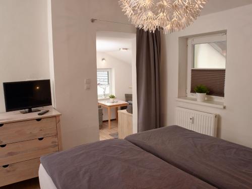 a bedroom with a bed and a television on a dresser at Karwendel Apartments in Scharnitz