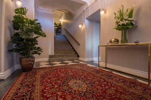 a hallway with a red rug on the floor and a staircase with a stair case at Hotel Gamla Stan, BW Signature Collection in Stockholm