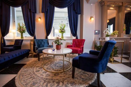 a living room with blue and red chairs and a table at Hotel Gamla Stan, BW Signature Collection in Stockholm