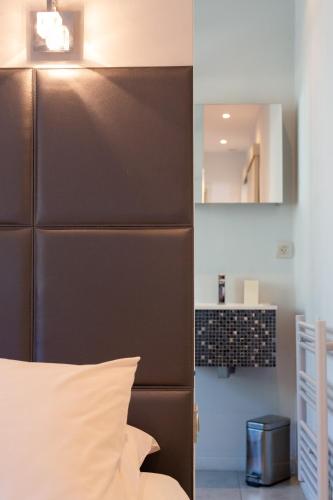 un lit avec une tête de lit brune dans une chambre dans l'établissement Cannes Vieux Port, à Cannes