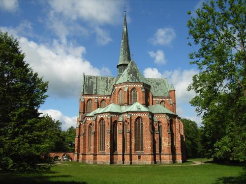 a large brick building with a steeple on top of it at Ostsee Hotel-Pension An der Lindenallee in Bad Doberan