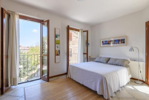 a bedroom with a bed and a large window at Casina PiP in Colle Val D'Elsa