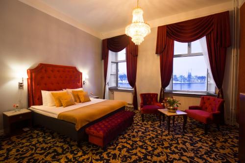 a bedroom with a bed and two chairs and a chandelier at Hotel Gamla Stan, BW Signature Collection in Stockholm