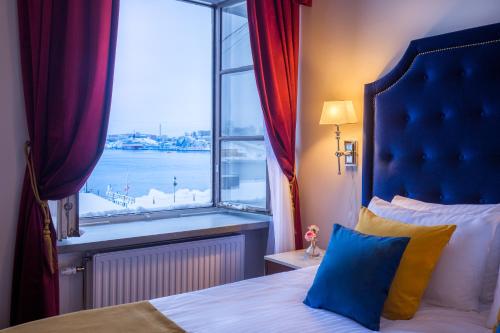 a bedroom with a window with a view of a harbor at Hotel Gamla Stan, BW Signature Collection in Stockholm