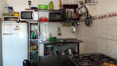 a small kitchen with a stove and a refrigerator at Chalézinho - Massaguaçu in Caraguatatuba
