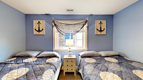 two beds in a room with blue walls and a window at Put-in-Bay Waterfront Condo #209 in Put-in-Bay