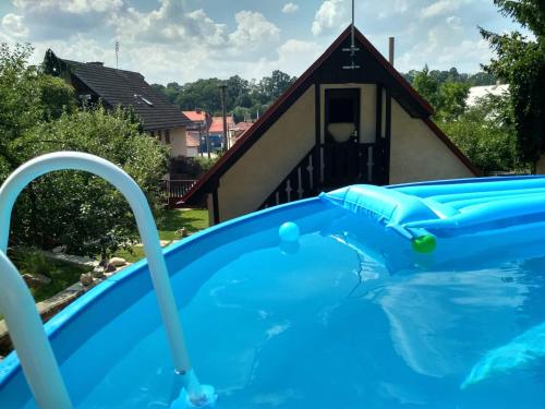 a large swimming pool in front of a house at Chalupa pod zámkem in Mnichovo Hradiště