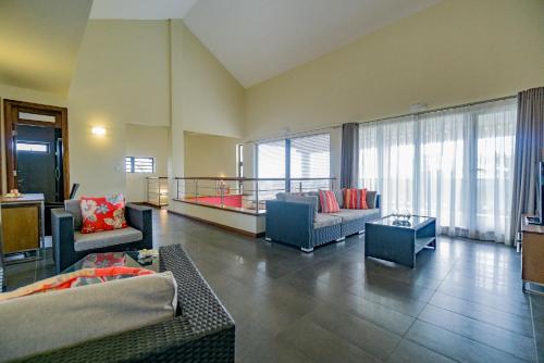 uma ampla sala de estar com sofás e uma varanda em Villasun Luxury Apartments & Villas em Flic-en-Flac