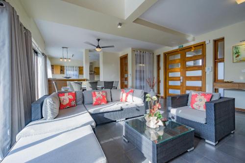 a living room with couches and a table at Villasun Luxury Apartments & Villas in Flic-en-Flac