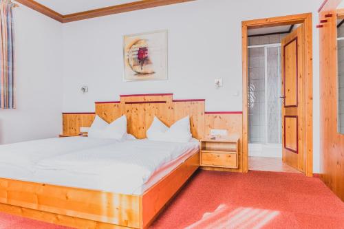 a bedroom with a large bed with a wooden headboard at Landgasthof Schwarzer Adler GbR in Dietenhofen