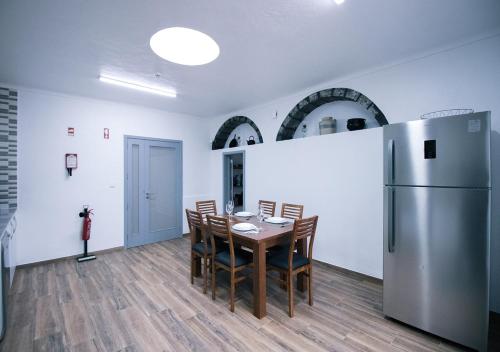 a dining room with a table and a refrigerator at Cantinho do Pensamento in Ribeira Grande
