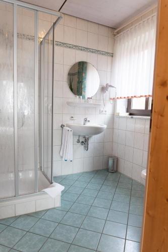 a bathroom with a sink and a shower at Landgasthof Schwarzer Adler GbR in Dietenhofen