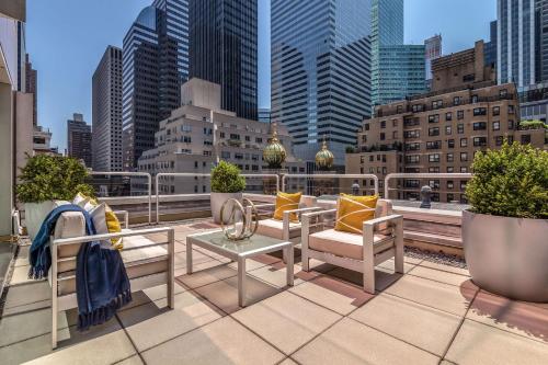 a balcony with chairs and tables on a city rooftop at Concorde Hotel New York in New York