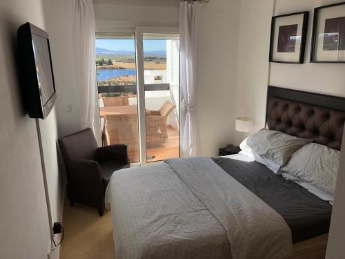 - une chambre avec un lit, une chaise et une télévision dans l'établissement Penthouse Apartment, à El Romero