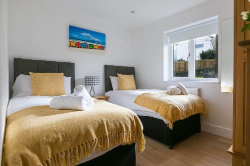 a bedroom with two beds and a window at Tara in St Ives