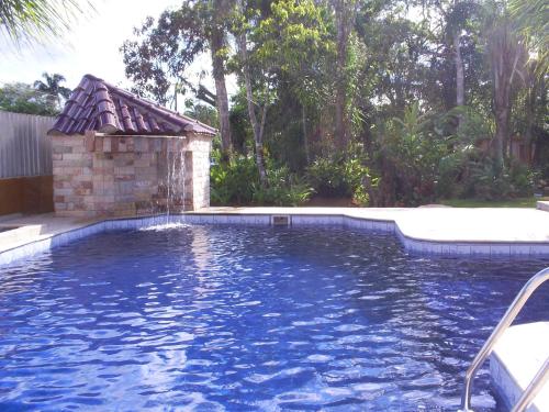 una piscina con una fuente de agua en Kitnets Park Verde, en Peruíbe