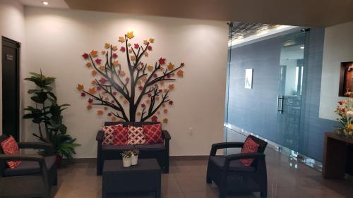 a waiting room with chairs and a plant on the wall at Terrass Hotel Zamora in Zamora de Hidalgo