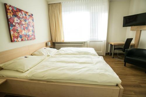 a large white bed in a room with a window at Bürgermeisterkapelle in Hildesheim